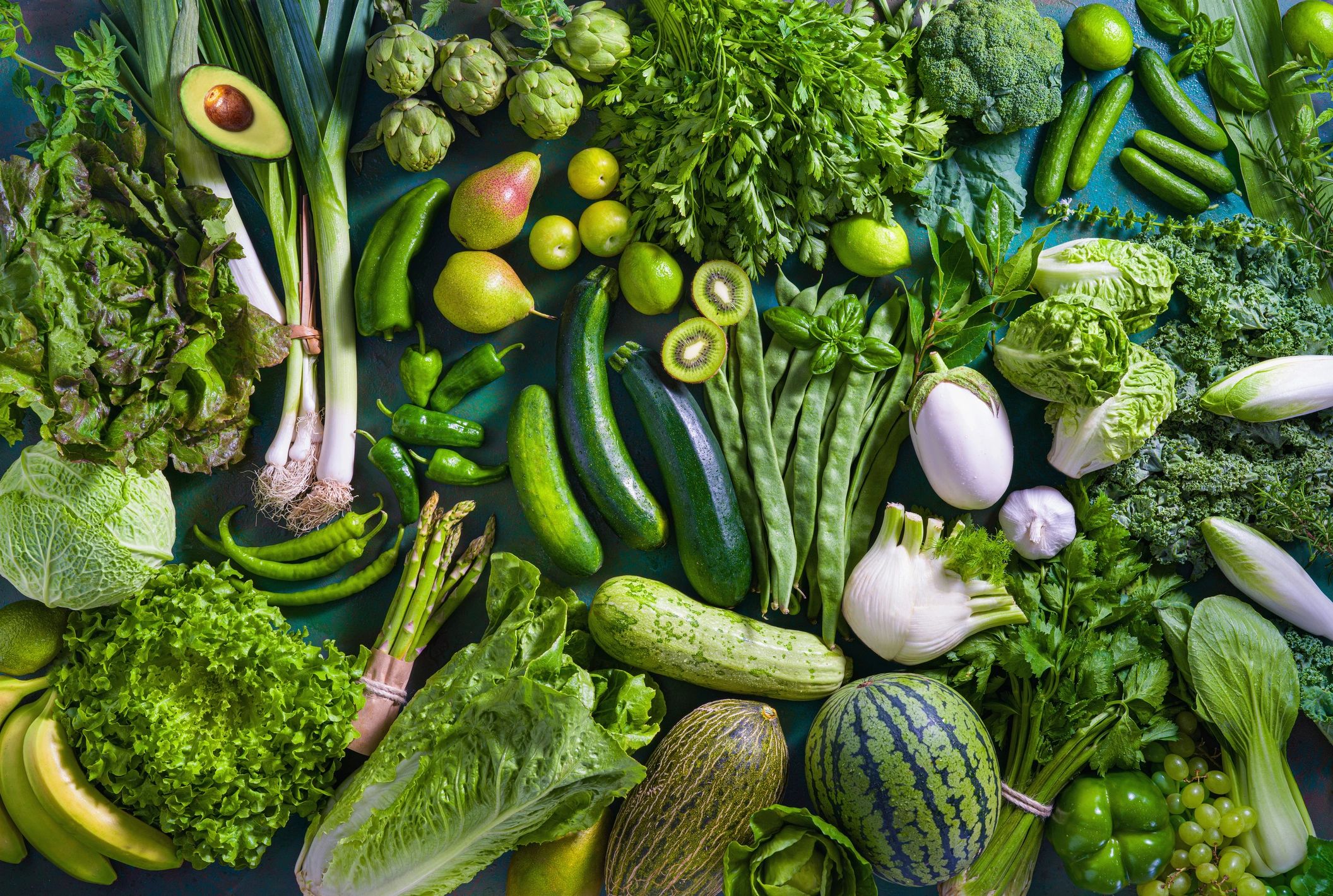 Assorted fruits and vegetables on a green table