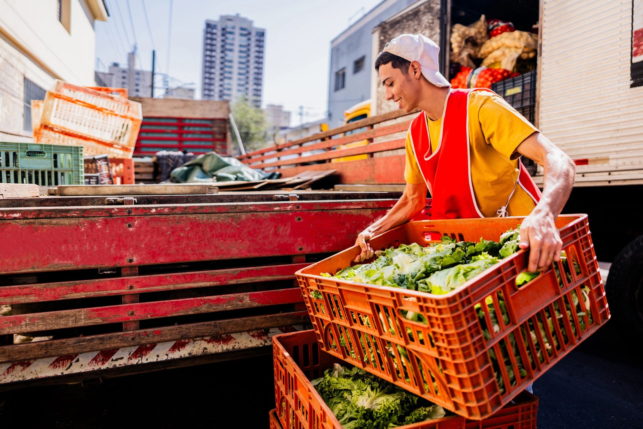 Person unloading boxes of vegetables from a truck